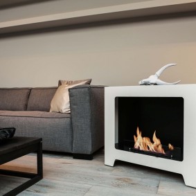 Grey sofa sa tabi ng isang compact fireplace