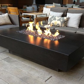 Outdoor biofuel fireplace with decorative pebbles