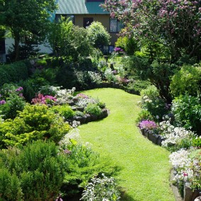 Een overvloed aan bloeiende struiken in een gemengde stijl tuin