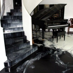 Czarny fortepian w hali ze schodami