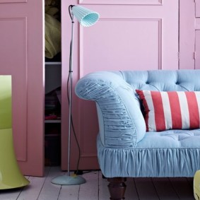 Sofá azul en una habitación con paredes rosas