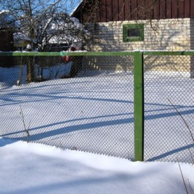 Valla de malla verde en invierno en la cabaña