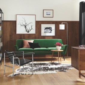 Sofá verde em uma sala com guarnição de madeira
