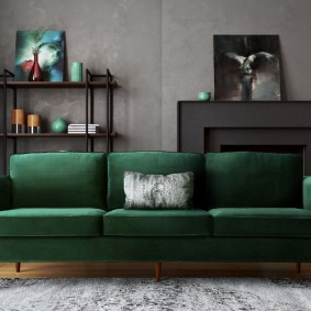 أريكة خضراء داكنة في غرفة ذات جدران رمادية