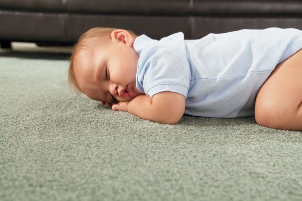 תינוק ישן על שטיח צבעוני ניטרלי