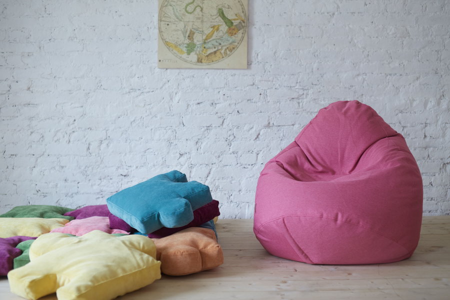 Pink bean bag chair on brick wall background