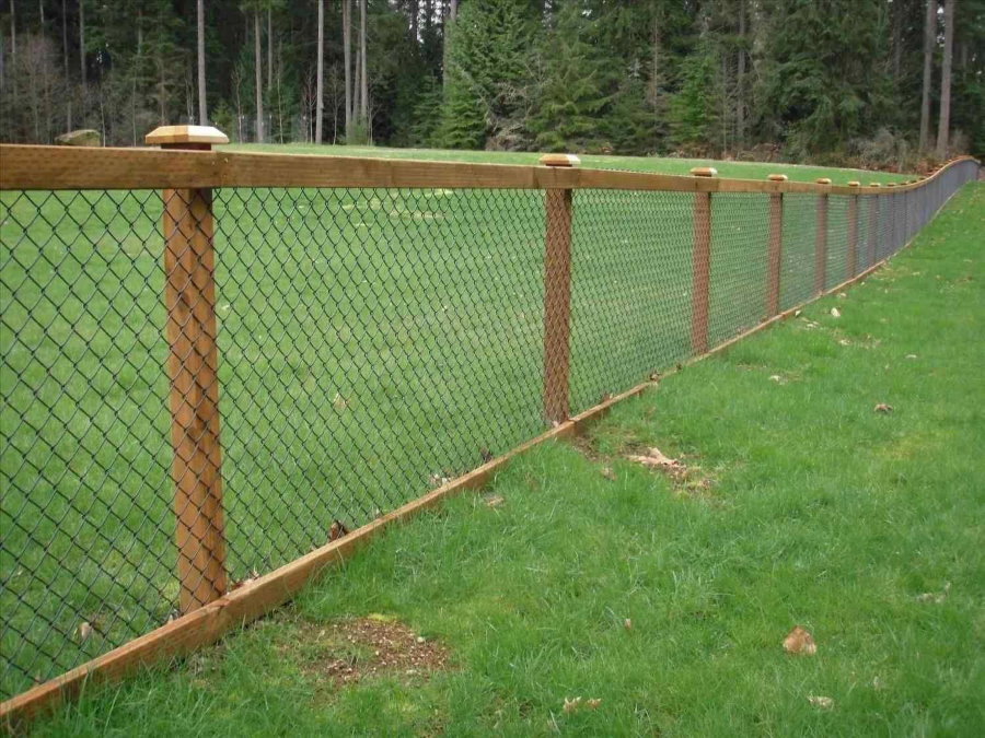 Sodo aikštelės tvora su grandininėmis grandinėmis ant medinių stulpų