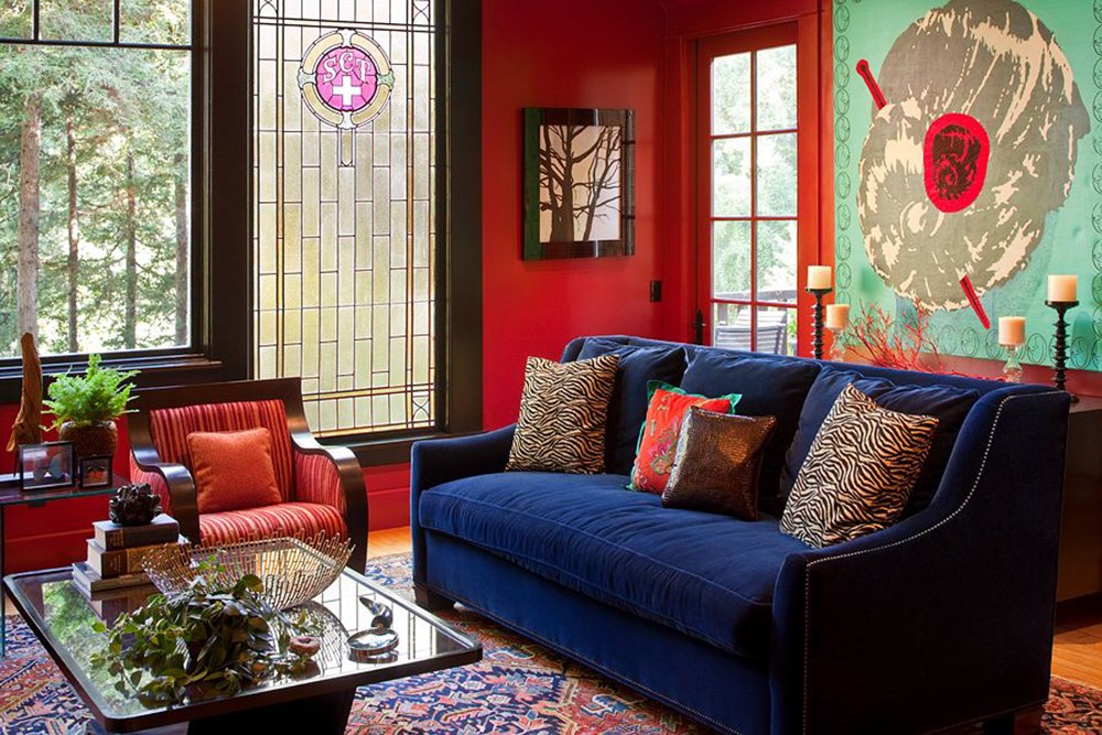 أريكة زرقاء في غرفة المعيشة مع جدران حمراء