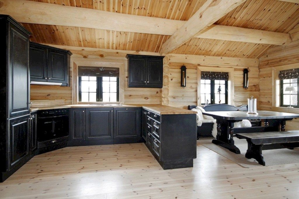 Sötét bútorok egy fából készült ház konyha-nappali szobájában