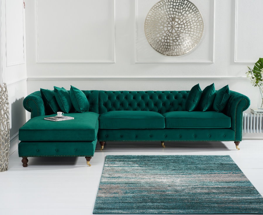 Smaragdinė kampinė sofa baltame kambaryje
