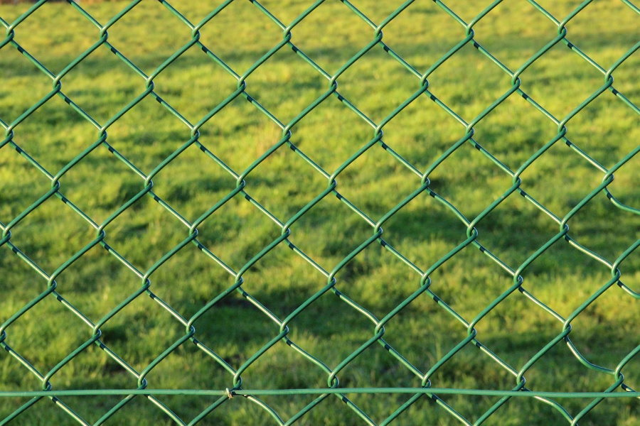 Green mesh netting sa isang bakod ng hardin