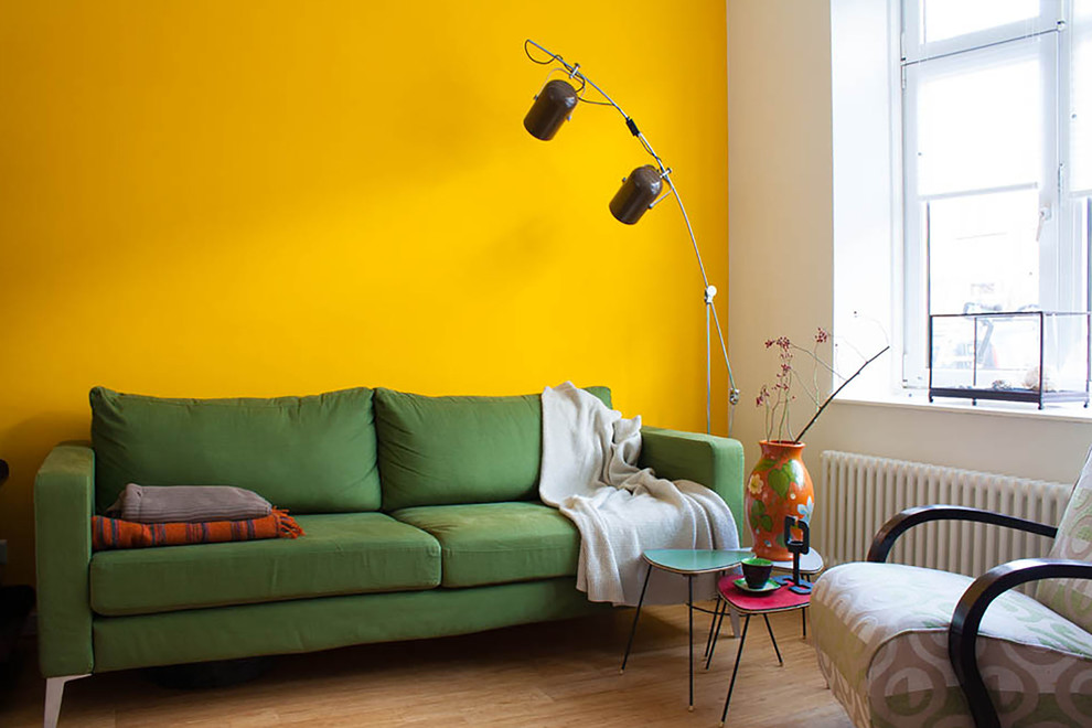 Sofá verde perto da parede amarela