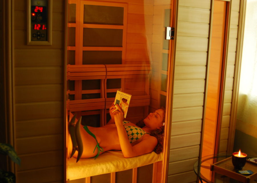 Girl in a compact sauna on a loggia of an apartment