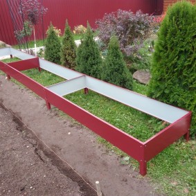 Frame of a metal bed in front of Canadian Christmas trees