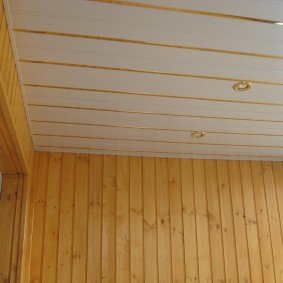 PVC panels with gilded decor on the ceiling of the loggia