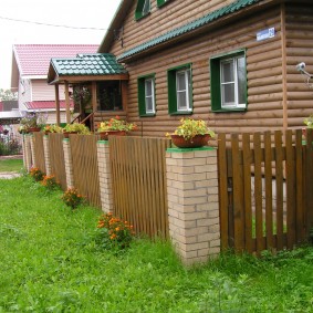Дървена ограда върху тухлени стълбове