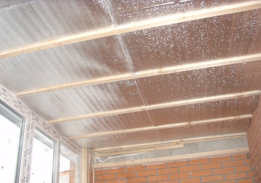 Lamelles en bois sur l'isolant film du plafond du balcon