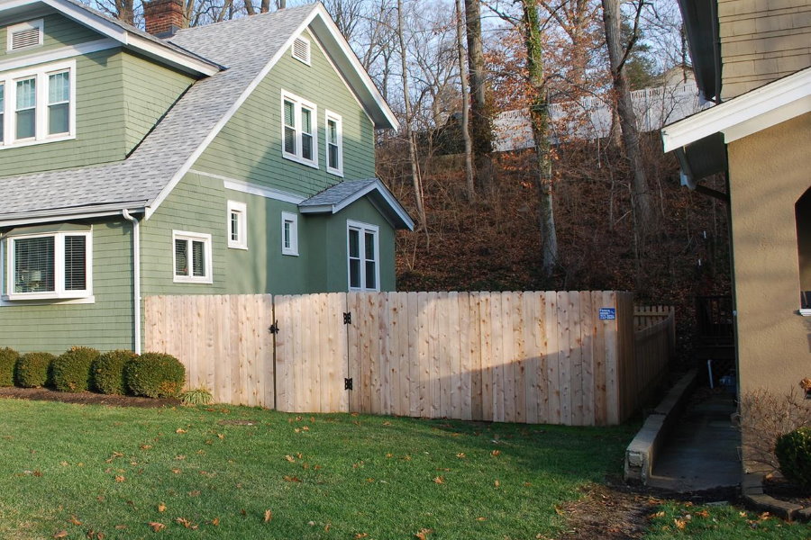 Fából készült kerítés a szomszédos házak között